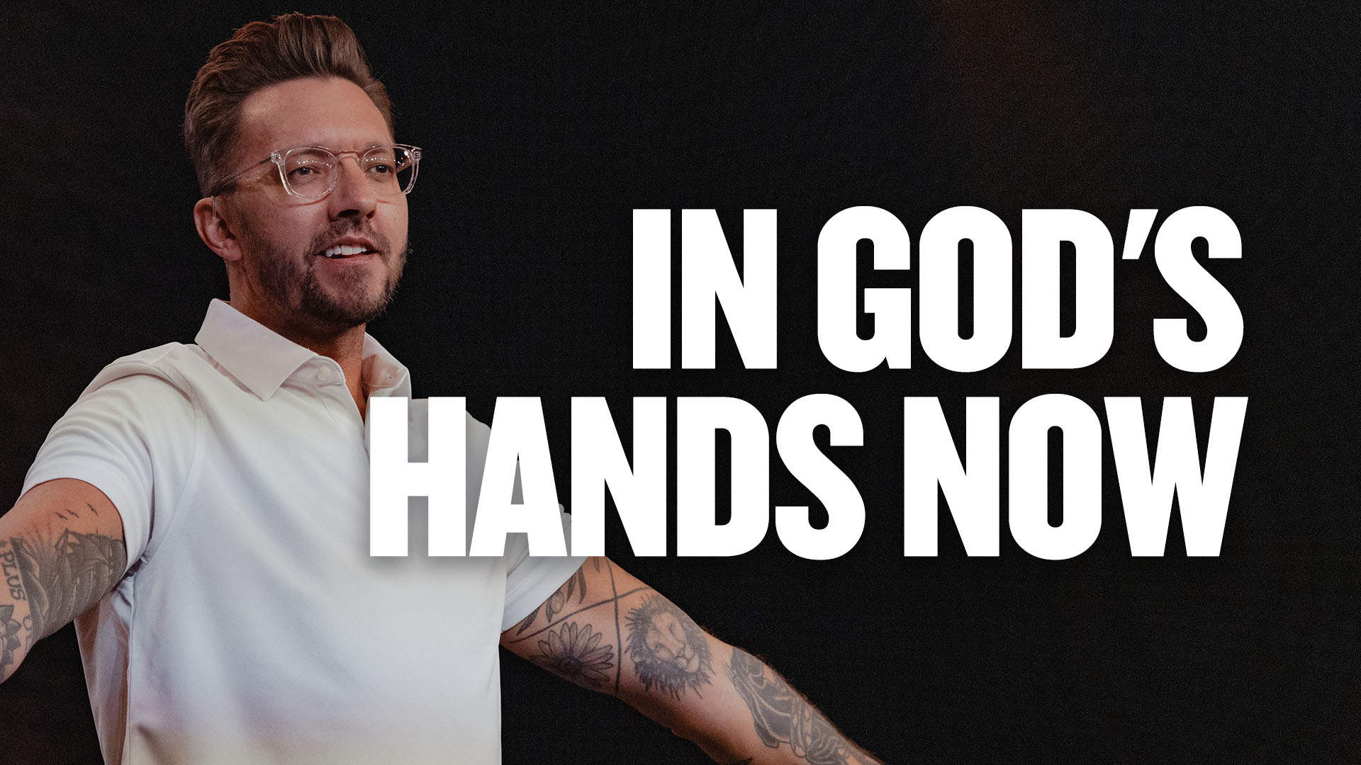 Pastor Levi Lusko stands facing out with his arms out.