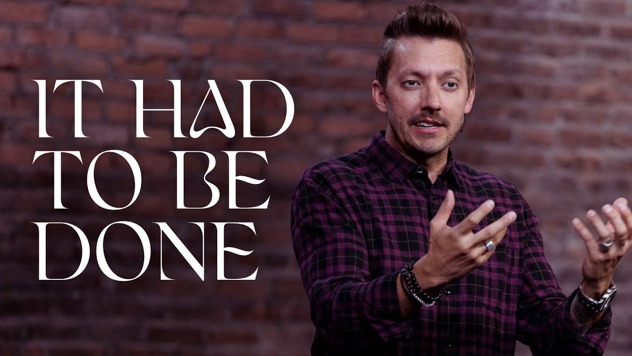 Pastor Levi Lusko stands with both hands open gesturing.