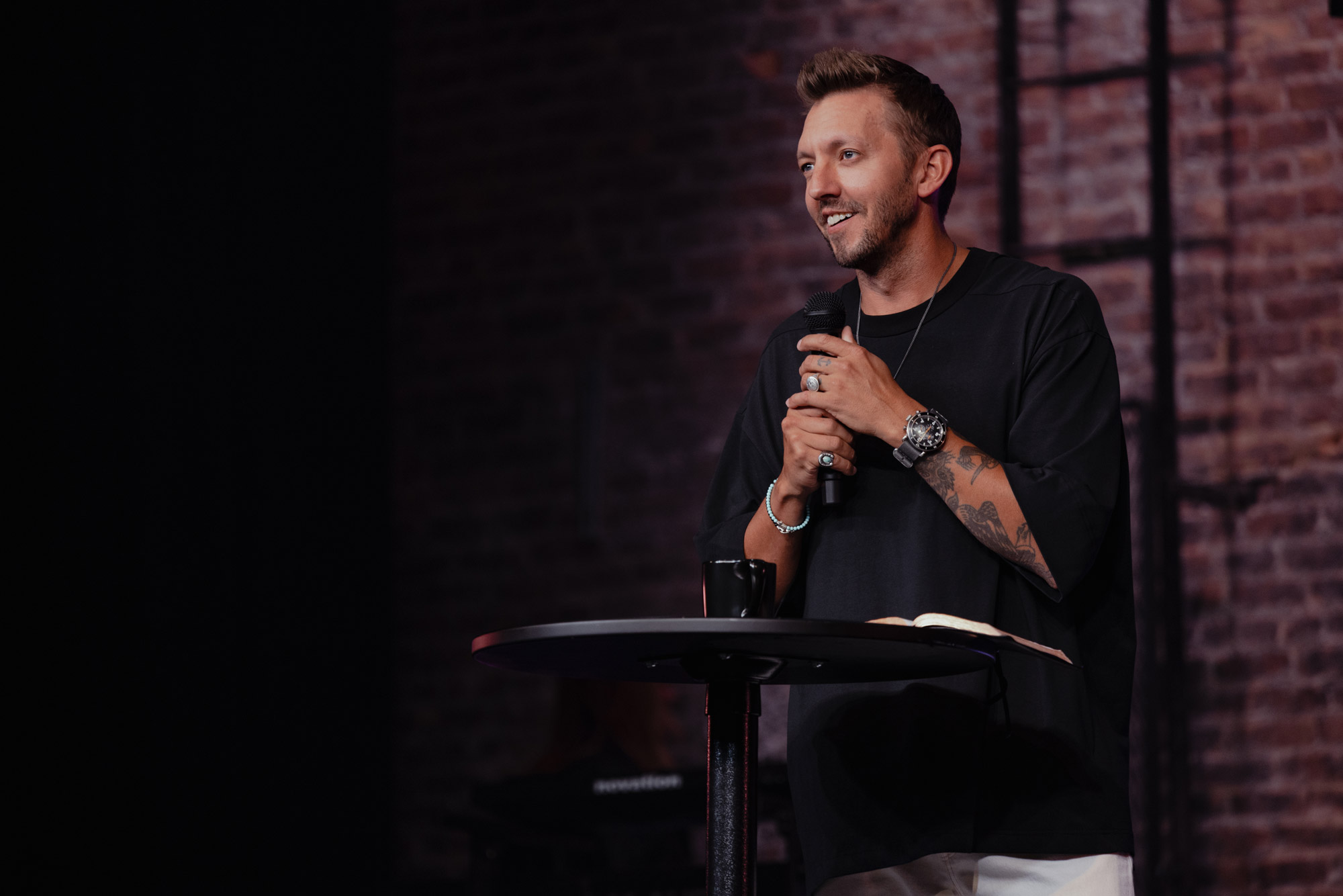 Levi Lusko holds a microphone and speaks to an audience.